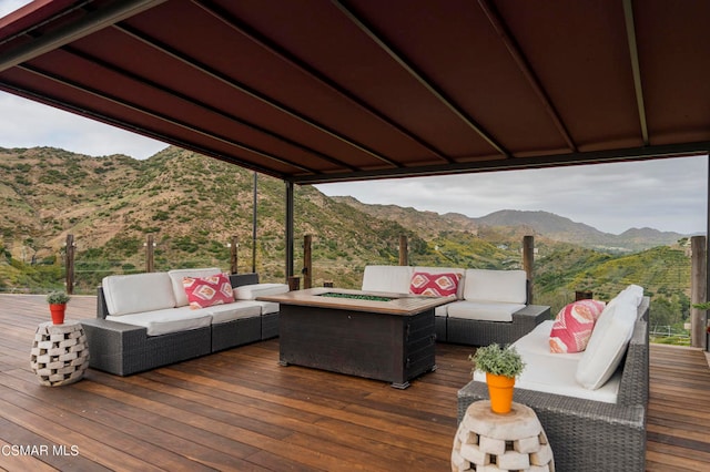 deck with an outdoor living space with a fire pit and a mountain view