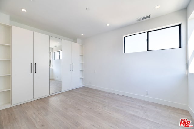 unfurnished bedroom featuring a closet and light hardwood / wood-style flooring