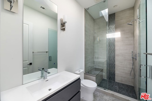 bathroom with vanity, a shower with shower door, and toilet