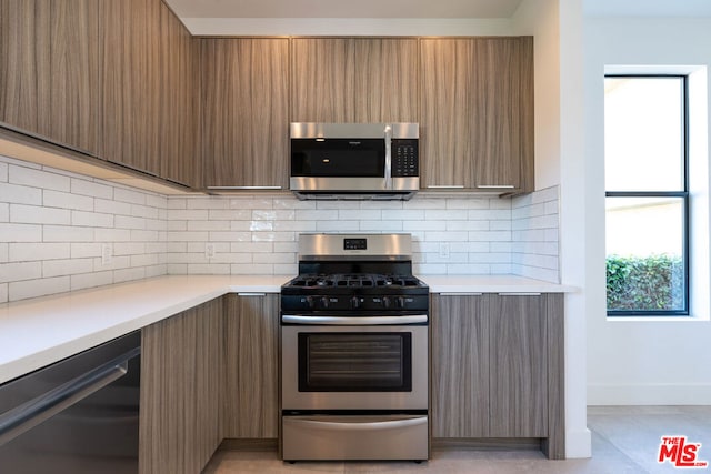 kitchen with stainless steel appliances and backsplash