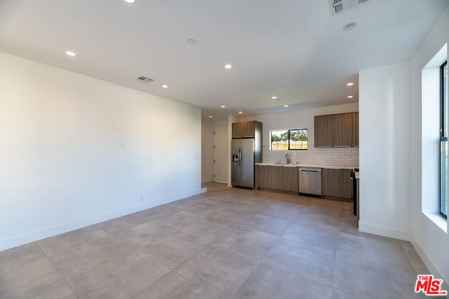 kitchen featuring stainless steel appliances, sink, and backsplash