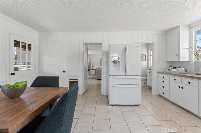3210 Live Oak Park Rd, Fallbrook, CA 92028 - kitchen with white fridge with ice dispenser, ornamental molding, light tile patterned floors, white cabinetry, and light countertops