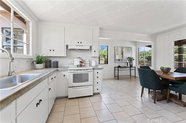 3210 Live Oak Park Rd, Fallbrook, CA 92028 - kitchen with white range with electric stovetop, under cabinet range hood, light countertops, light tile patterned floors, and white cabinets
