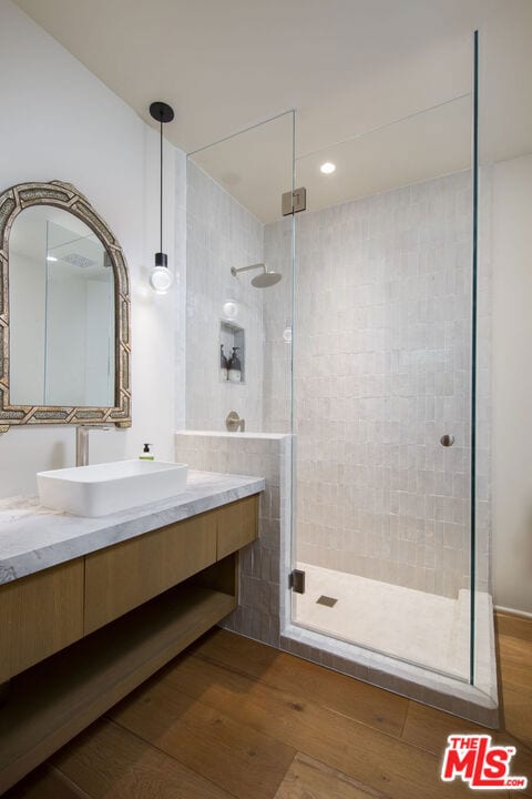 bathroom with vanity, an enclosed shower, and hardwood / wood-style floors