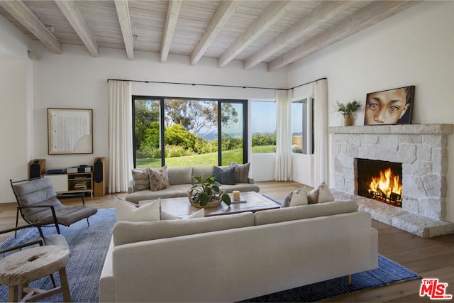 living room featuring hardwood / wood-style flooring, a fireplace, and beamed ceiling