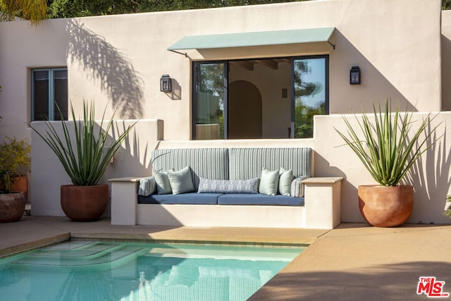 back of house with outdoor lounge area, a fenced in pool, and a patio area