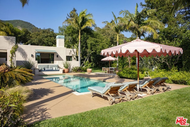 view of pool with a patio, a mountain view, and an outdoor hangout area