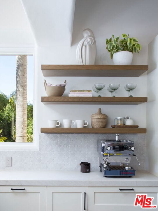 bar featuring white cabinets and decorative backsplash