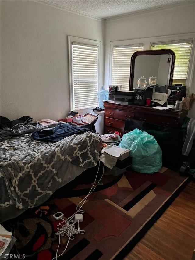 bedroom with hardwood / wood-style flooring, multiple windows, and a textured ceiling