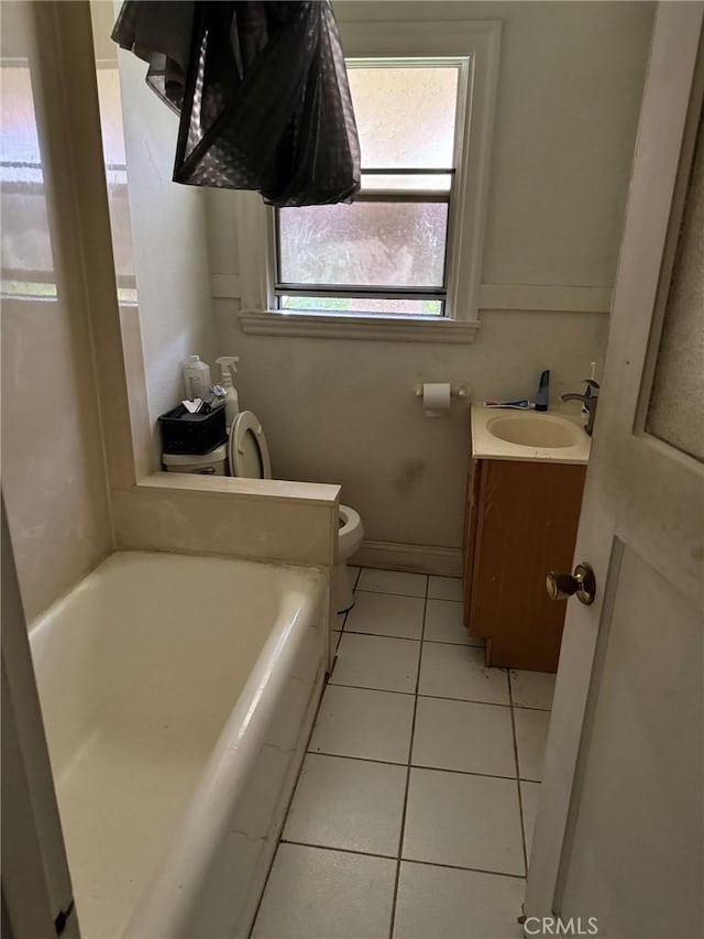 2123 High St, Oakland, CA 94601 - bathroom with a bathing tub, baseboards, toilet, tile patterned floors, and vanity