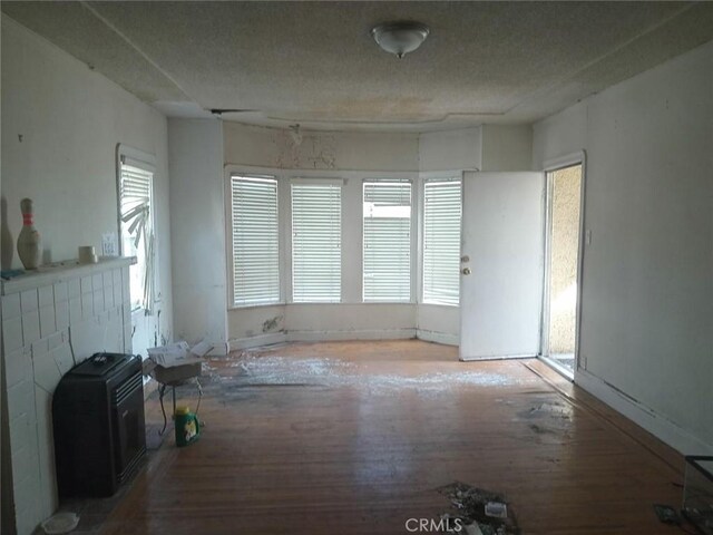2123 High St, Oakland, CA 94601 - unfurnished living room with wood finished floors, a healthy amount of sunlight, and a textured ceiling
