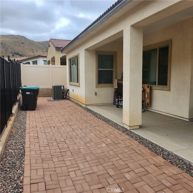 view of patio / terrace featuring a mountain view and central air condition unit