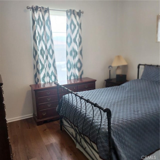 bedroom with dark hardwood / wood-style floors