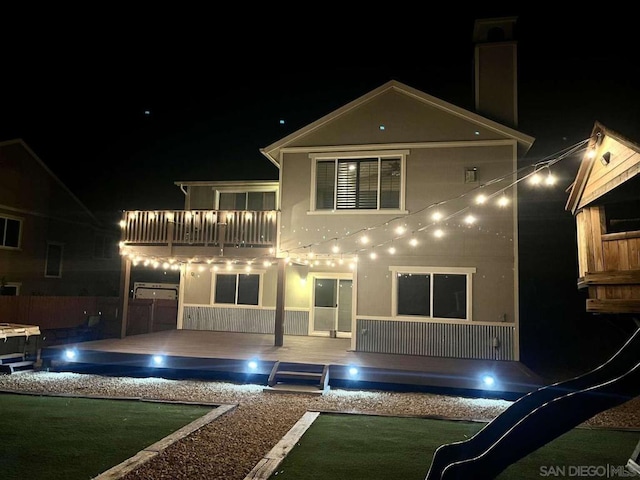 back house at twilight with a balcony