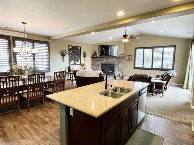 kitchen with vaulted ceiling, a healthy amount of sunlight, sink, and a kitchen island with sink