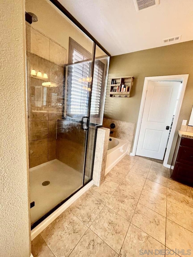 bathroom with vanity, plus walk in shower, and tile patterned flooring