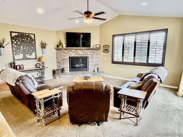 living room with ceiling fan, carpet flooring, vaulted ceiling, and a fireplace