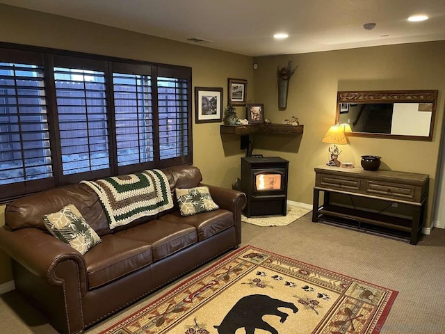 living room featuring a wood stove and carpet