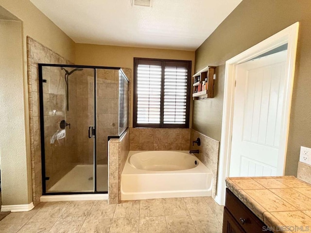 bathroom with tile patterned flooring, separate shower and tub, and vanity