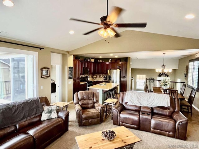 living room with lofted ceiling, sink, light carpet, and ceiling fan with notable chandelier