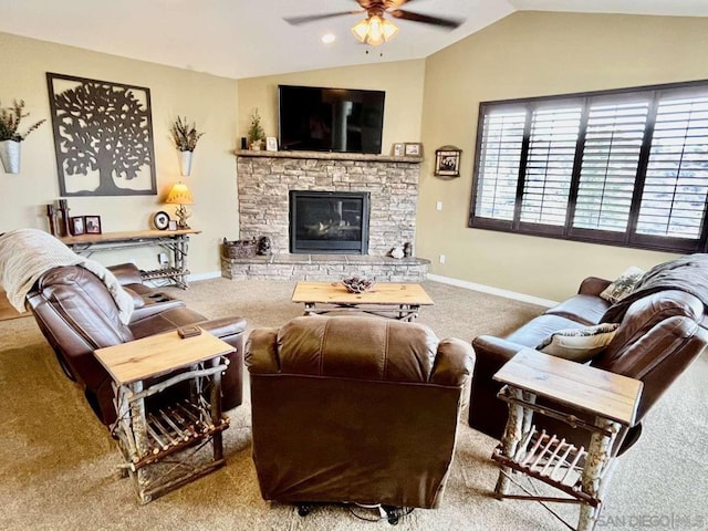 carpeted living room featuring a stone fireplace, lofted ceiling, and ceiling fan