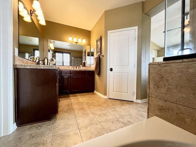 bathroom featuring vanity, tile patterned floors, and vaulted ceiling