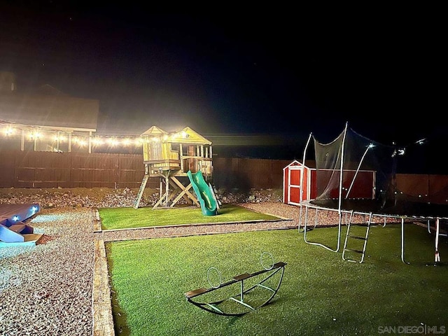 playground at night with a storage unit and a lawn