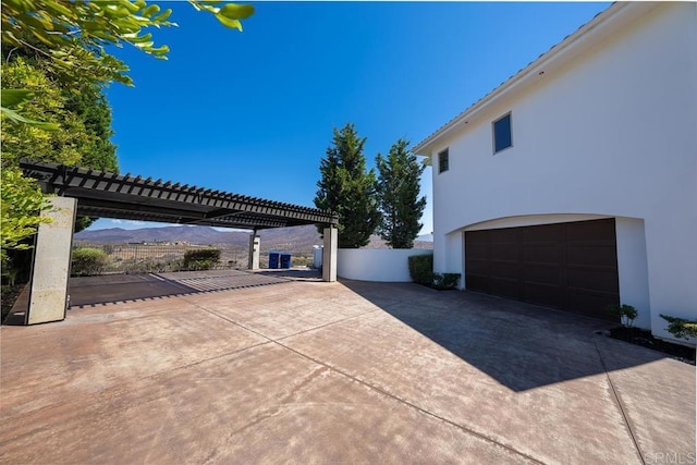 view of patio / terrace featuring a garage and a mountain view