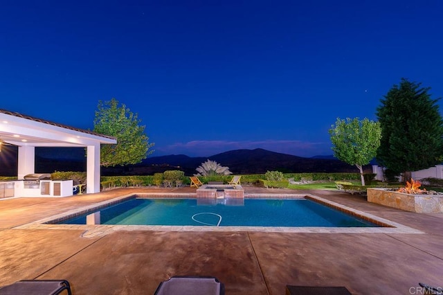 view of swimming pool featuring a patio, a mountain view, area for grilling, and an in ground hot tub