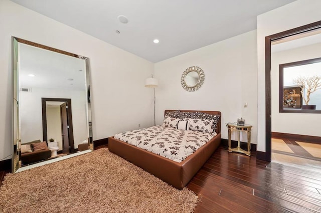 bedroom with dark hardwood / wood-style floors