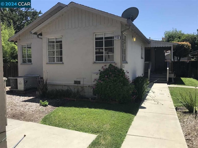 view of home's exterior with a lawn and central AC unit