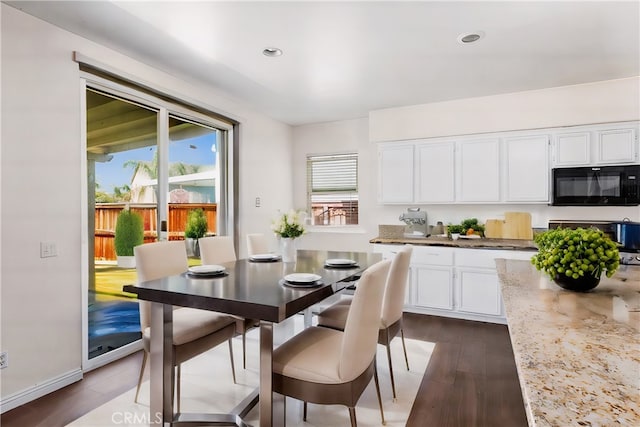 kitchen with white cabinetry, light stone counters, range, and dark hardwood / wood-style flooring