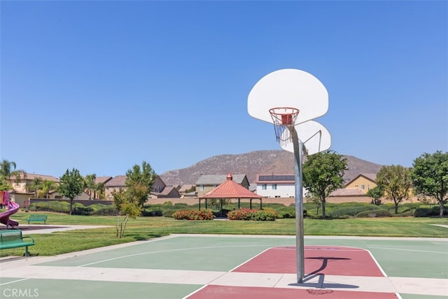 view of sport court with a gazebo, a mountain view, and a lawn