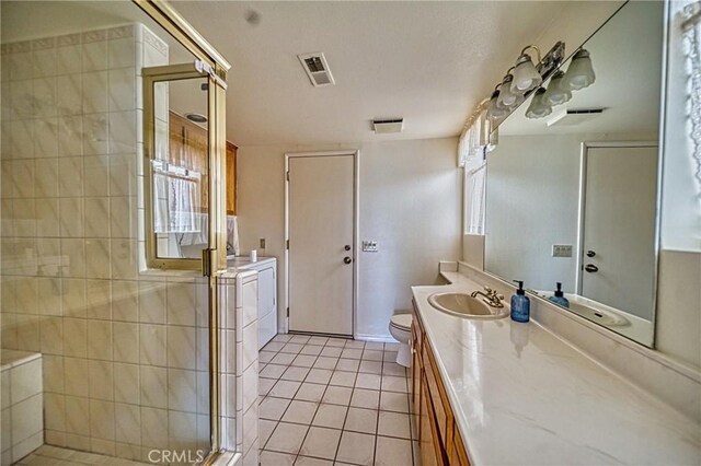 bathroom with toilet, tile patterned flooring, vanity, a textured ceiling, and walk in shower