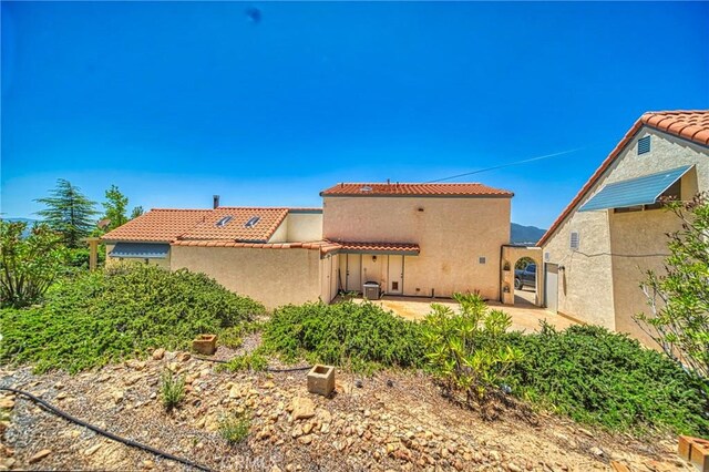 rear view of property with central air condition unit and a patio area