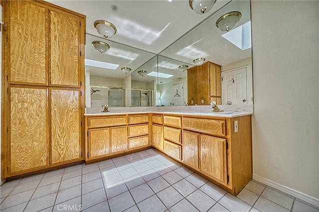 bathroom featuring a shower with door, vanity, and a skylight