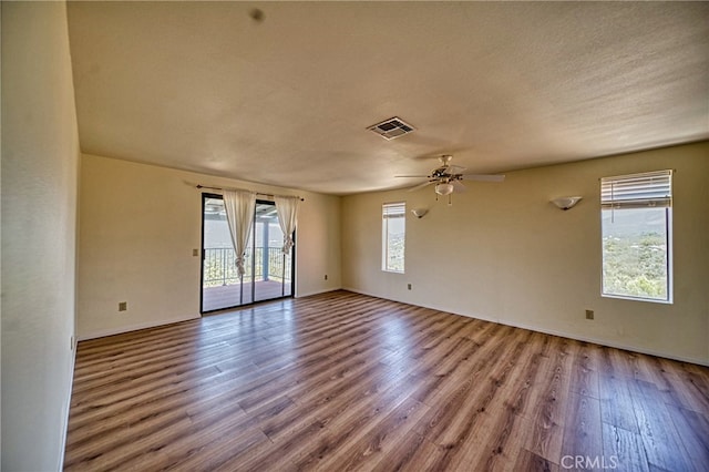 spare room featuring light hardwood / wood-style floors, a textured ceiling, ceiling fan, and a wealth of natural light