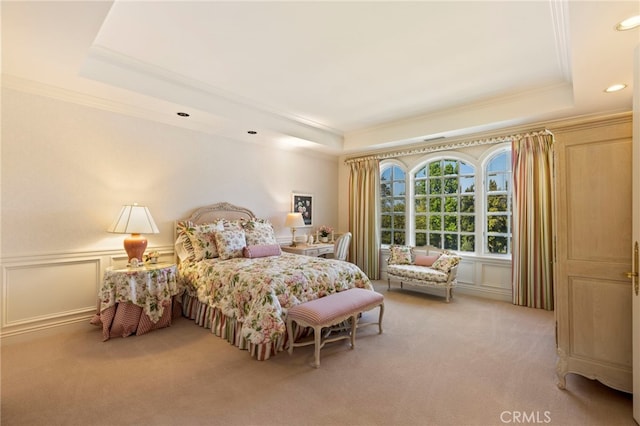 carpeted bedroom featuring a tray ceiling and ornamental molding