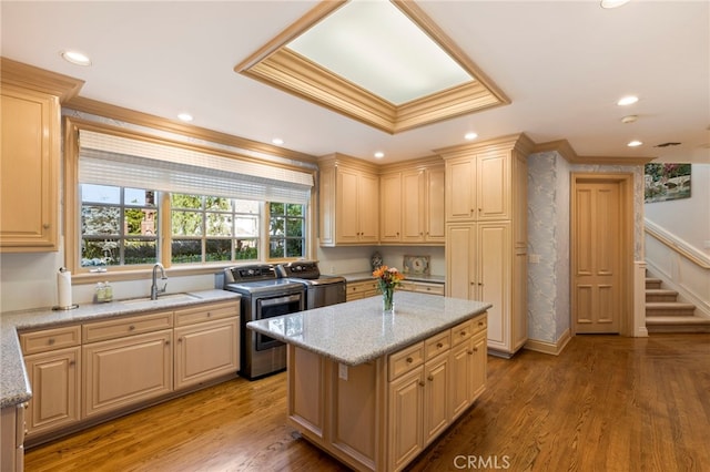 kitchen featuring hardwood / wood-style flooring, washer and dryer, and light stone countertops