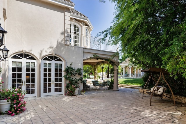 view of patio with french doors and a balcony