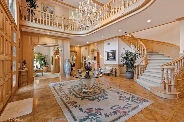 entryway featuring crown molding, a high ceiling, and light parquet floors