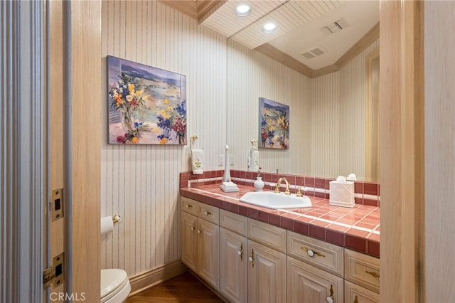 bathroom with wood-type flooring, vanity, and toilet