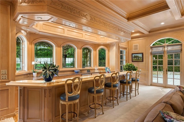 bar with light carpet, french doors, coffered ceiling, crown molding, and beamed ceiling