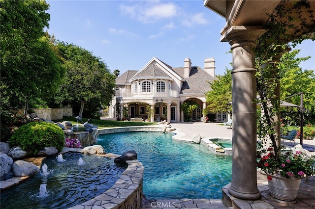 view of pool featuring an in ground hot tub, pool water feature, and a patio