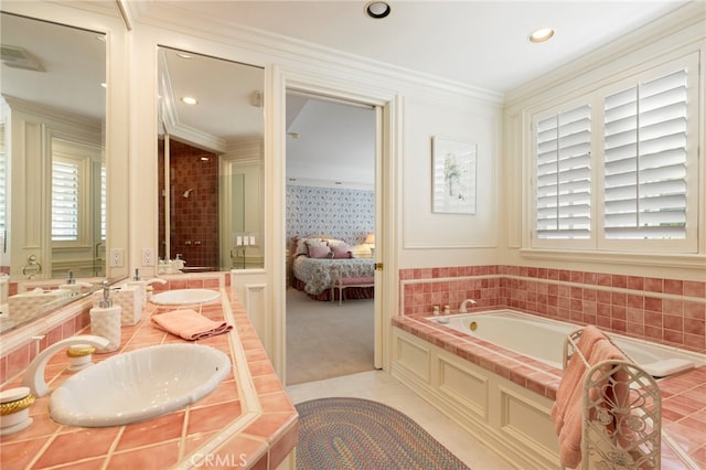 bathroom with tile patterned floors, tiled tub, vanity, and ornamental molding