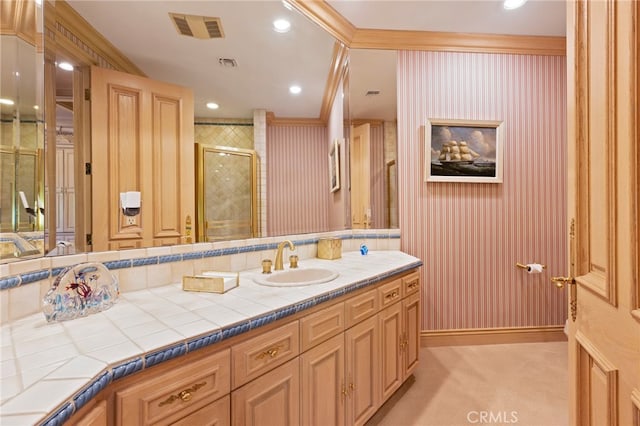 bathroom with crown molding, vanity, and an enclosed shower