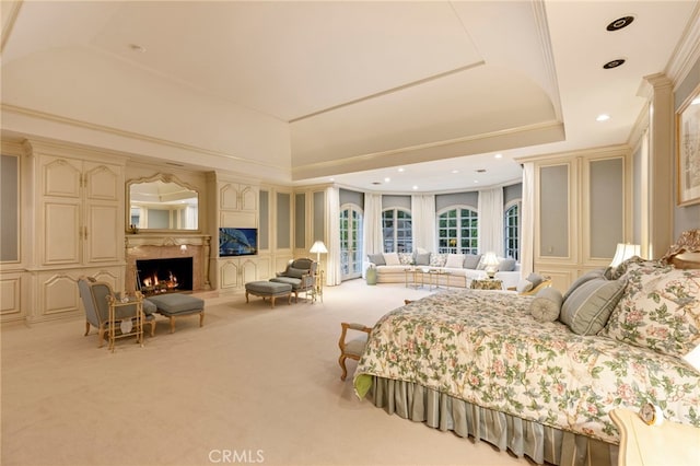 carpeted bedroom featuring a tray ceiling and ornamental molding