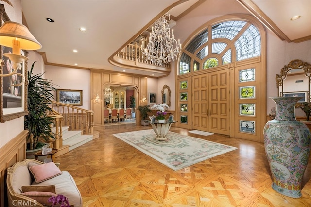 entryway featuring crown molding, light parquet flooring, and a notable chandelier