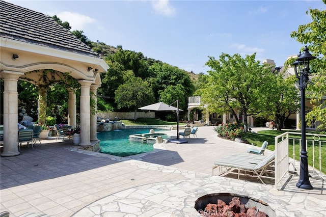 view of swimming pool with an in ground hot tub and a patio