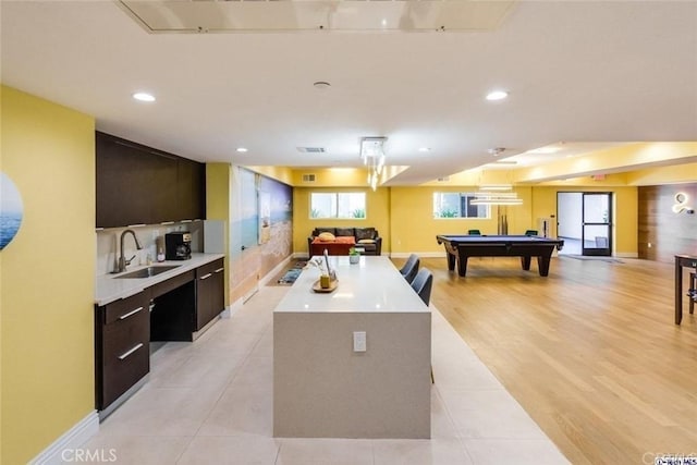 kitchen featuring sink, a center island, pool table, and dark brown cabinets